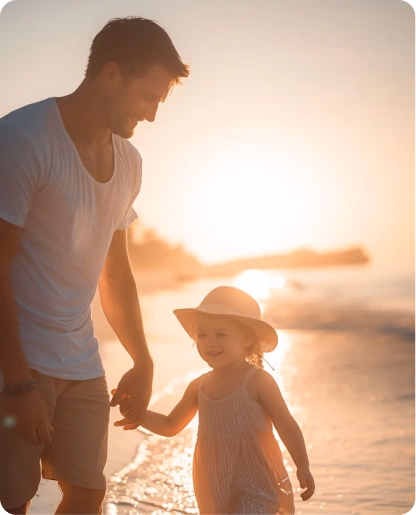 Père et fille marchant sur la plage au coucher du soleil
